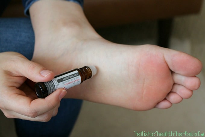 Photo of using a roll-on on the bottoms of the feet.